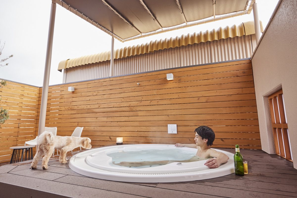 Relaxing in the onsen jacuzzi on a guest-room terrace, with a dog alongside